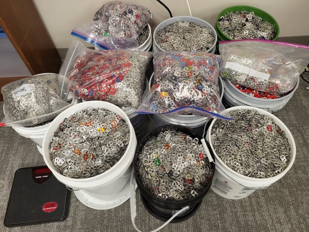 Several buckets filled with pull tabs from cans